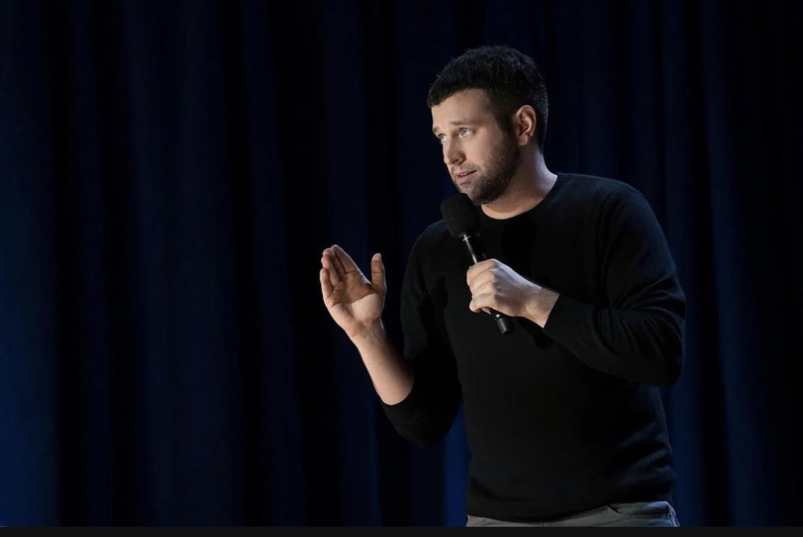 Brent Morin performing stand-up with a microphone